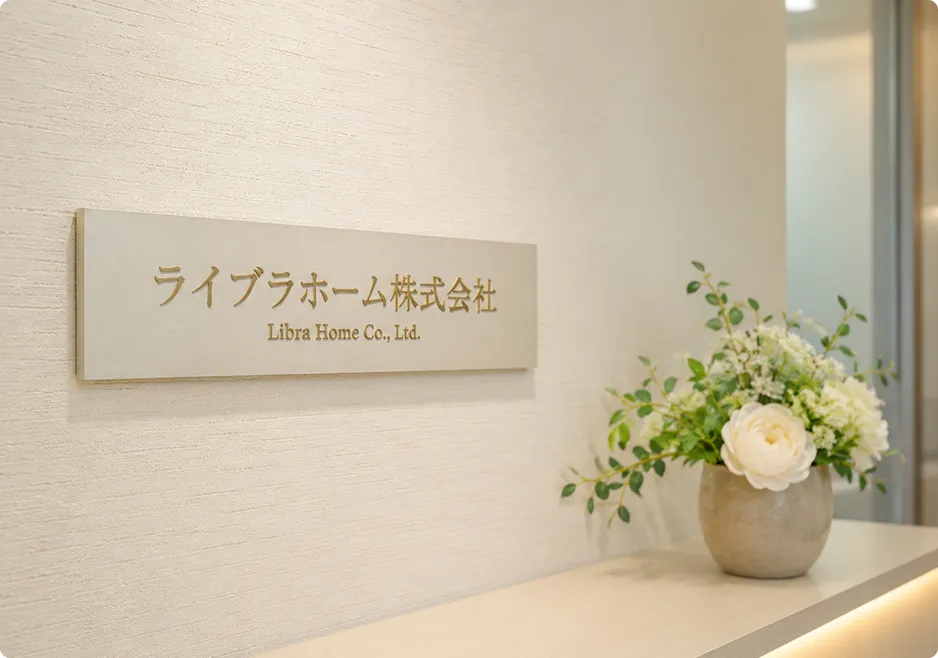 オフィスの受付に飾られた会社の看板と白い花。